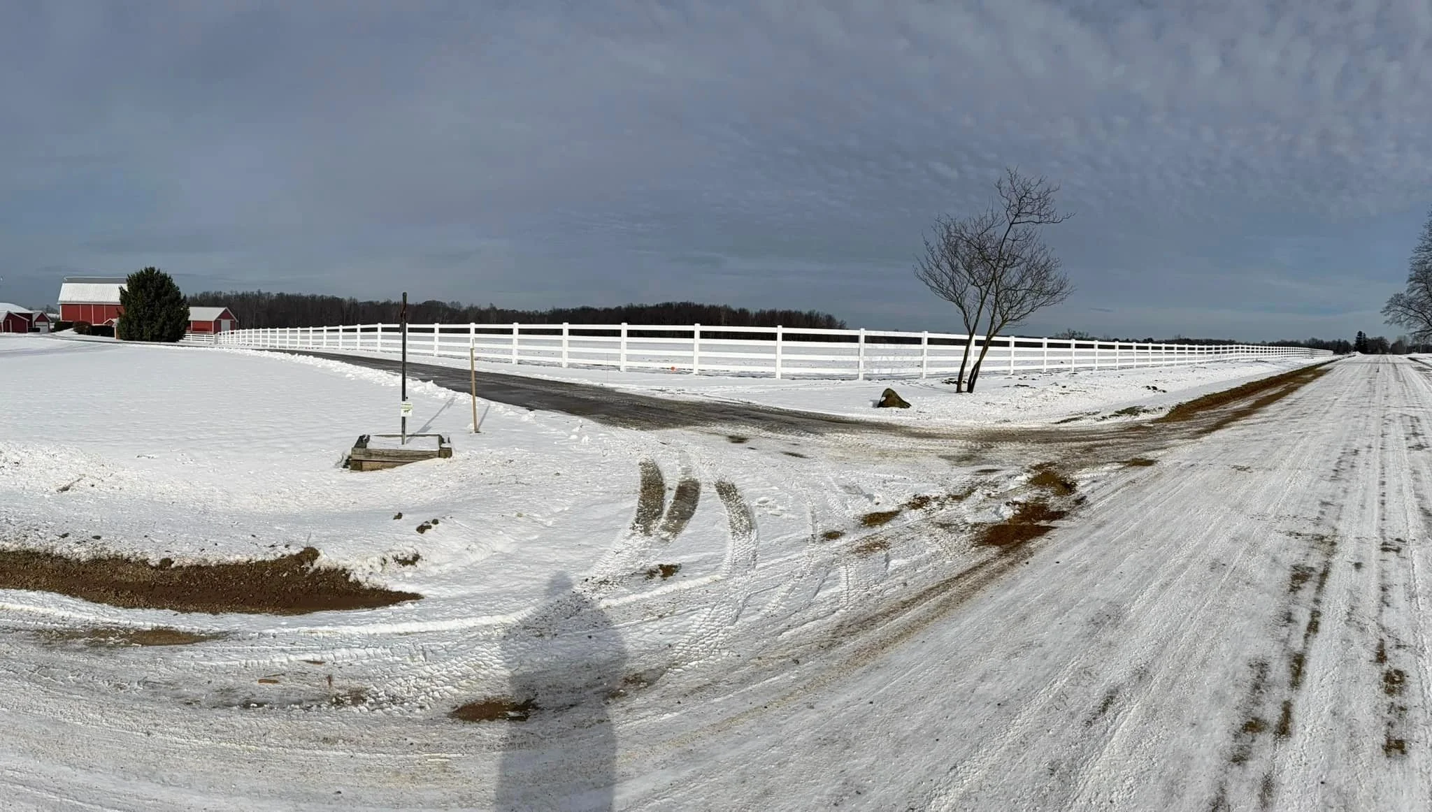 Long rail fence run along open ground in winter, showing a clean line and consistent posts through the season.