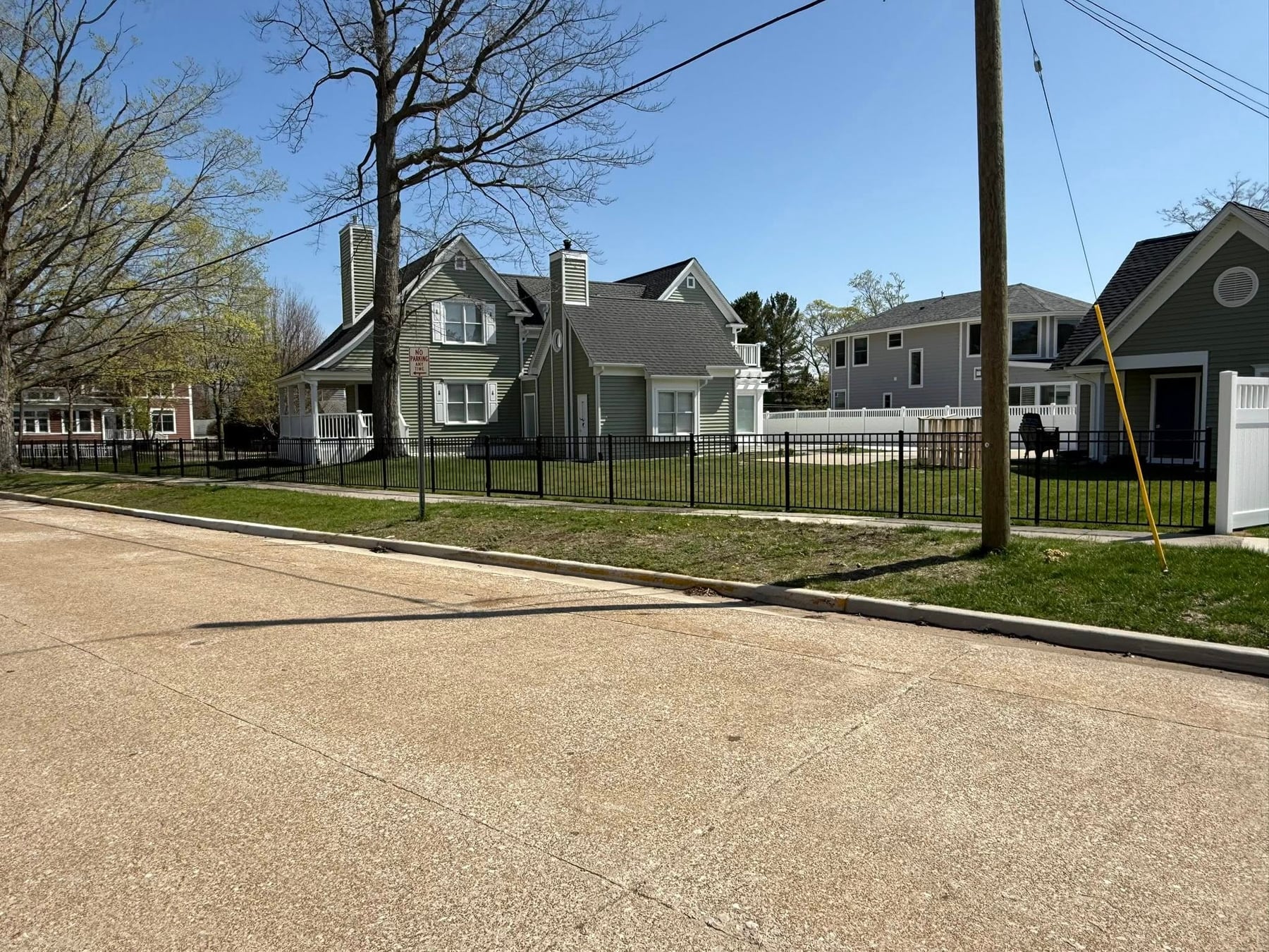 Aluminum fence line across a corner-lot yard.