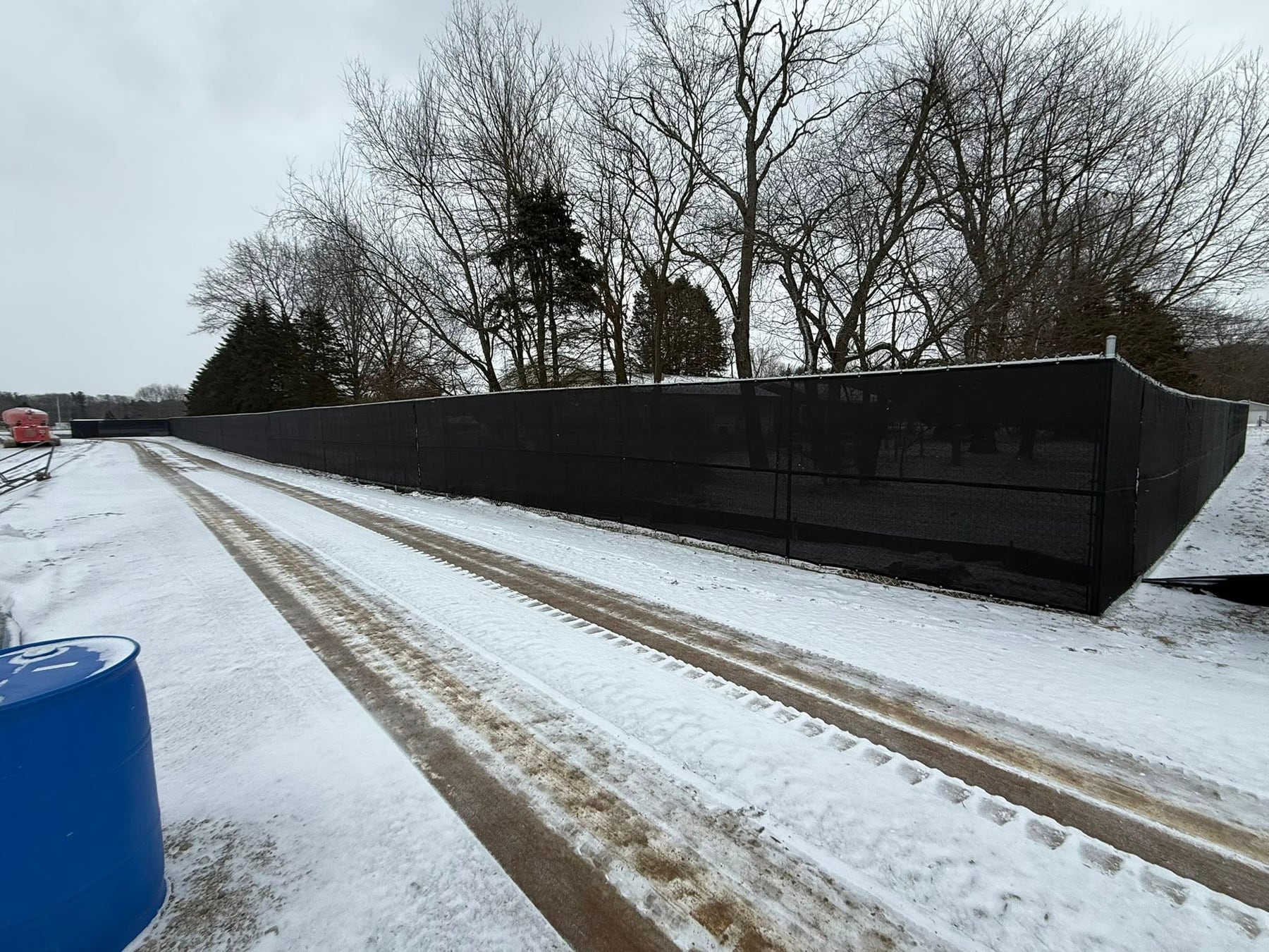 White vinyl privacy fence run along a driveway with a clean, consistent line and finished posts.