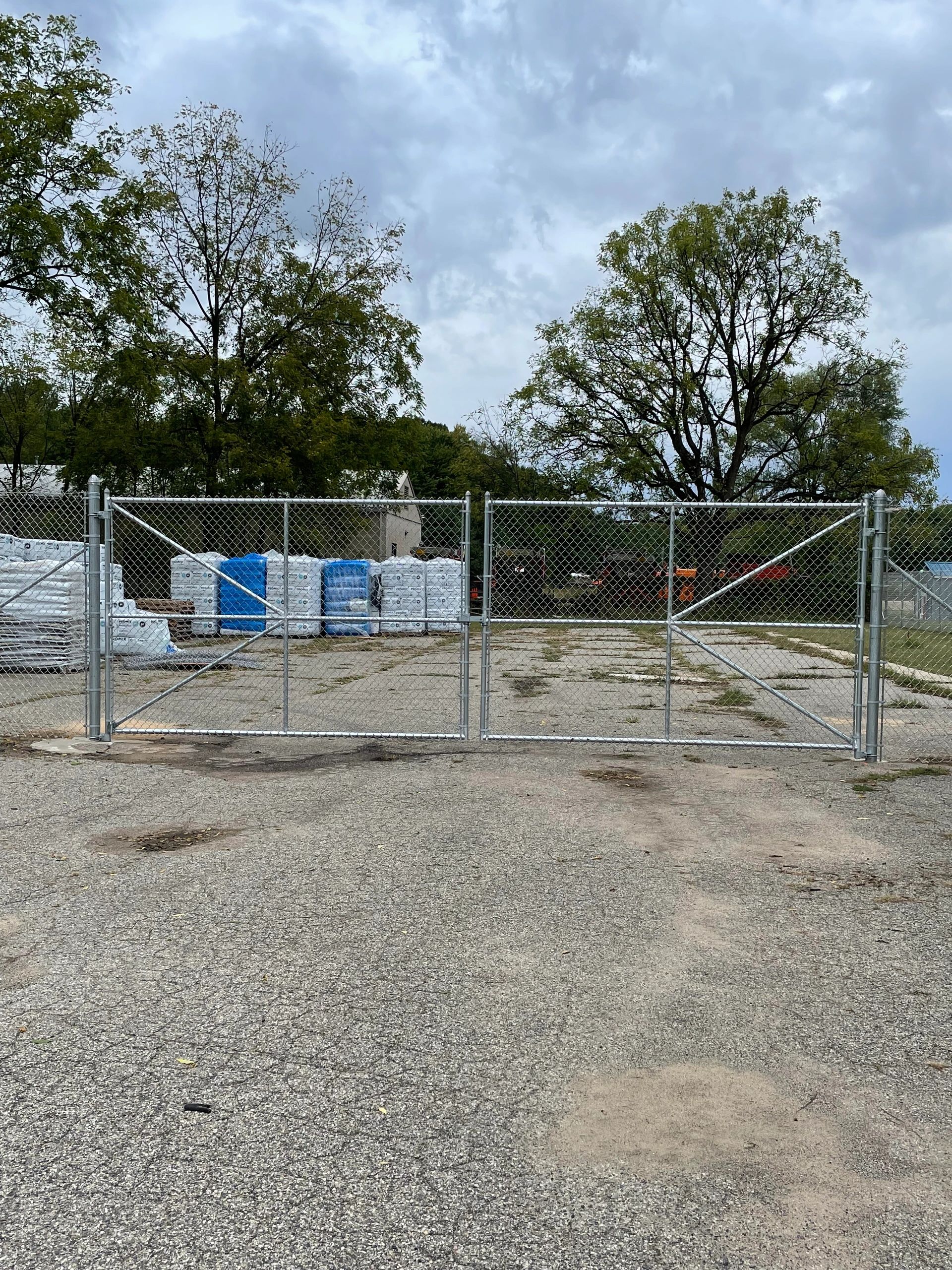 Chain link double drive gate securing a yard entrance with room for vehicle access.